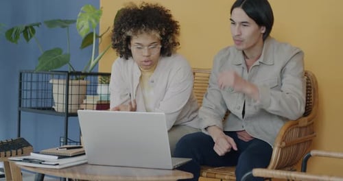 Students Male and Female Studying Together Doing Research Using Laptop Indoors on Campus