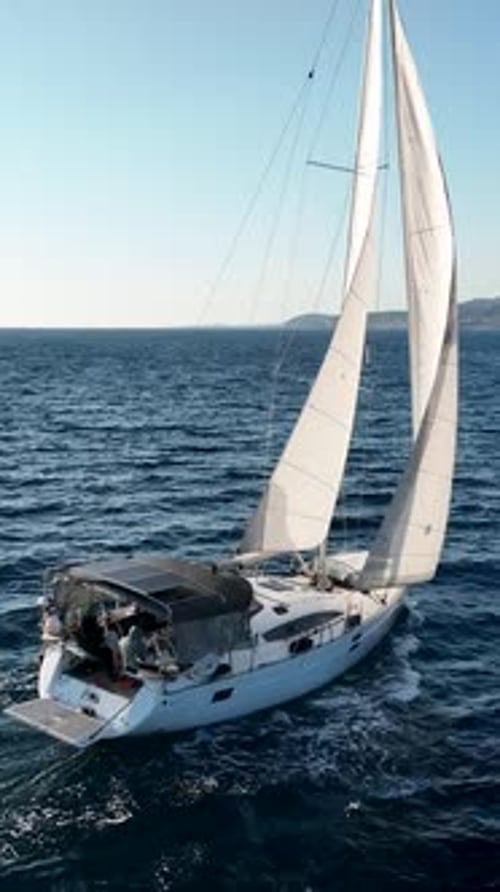 Vertical Video Nautical Elegance Yacht's Voyage to the Port on the Mediterranean Coast