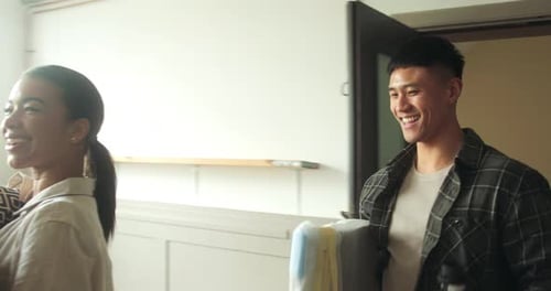 Fröhliches erwachsenes Paar zieht in ein neues Zuhause ein, trägt Boxen und umarmt sich