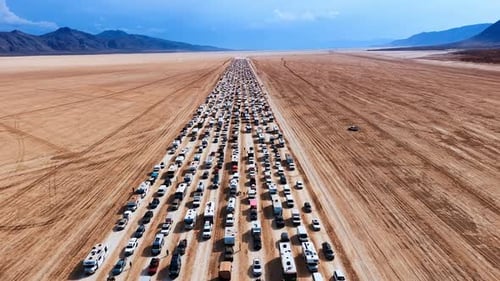 Flight over the rows of cars and campervans moving slowly by the desert.