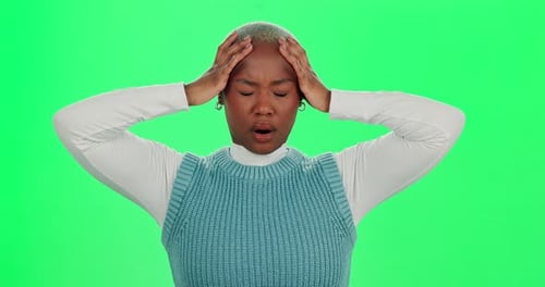 Anxiety, headache and stress with black woman on green screen in studio for crisis, fail or mistake