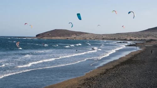 Kitesurf-Athleten führen im Sommer extreme Wassersportarten an der Inselküste von Teneriffa aus