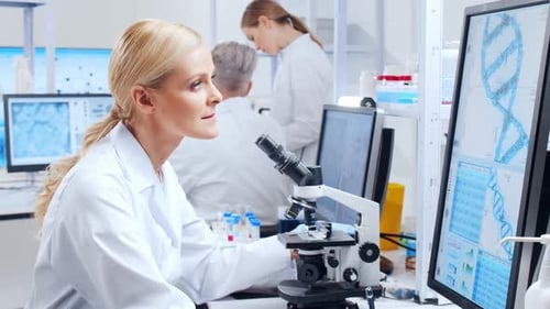 Female Scientist Using Microscope in Bright Lab