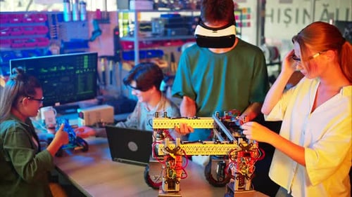 Young engineers with VR virtual reality headset fixing a robotic car in research laboratory, slow mo