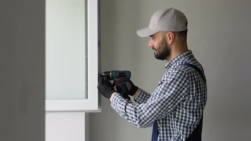 A Repairman in Uniform Fixing Pvc Windows in New Apartment