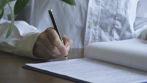 Businesswoman signing documents, contracts, legal agreements, papers in the office. Signature