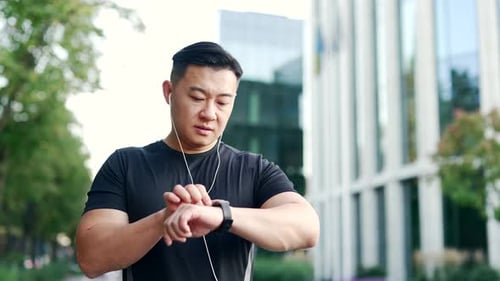 Fit Man Using Smart Watch in City