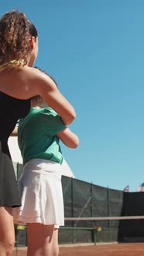 Tennis Instructor Coaching Girl on Sunny Court