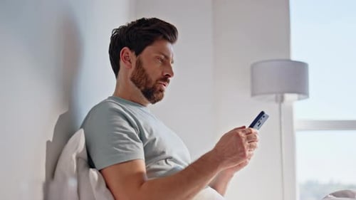 Morning Guy Looking Cellphone in Bed Feeling Disappointed Closeup Upset Man