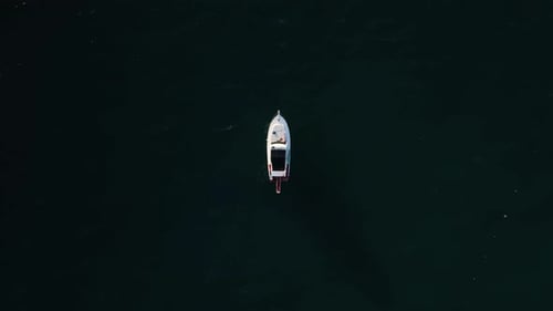 Aerial Drone Tracking Top Down Video of Yacht Cruising in Deep Blue Open Ocean Sea