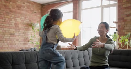 Little Girl Playing with Balloons with Adult Woman