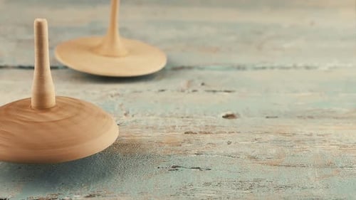 Wooden Spinning Tops Rotate on Painted Wood Surface