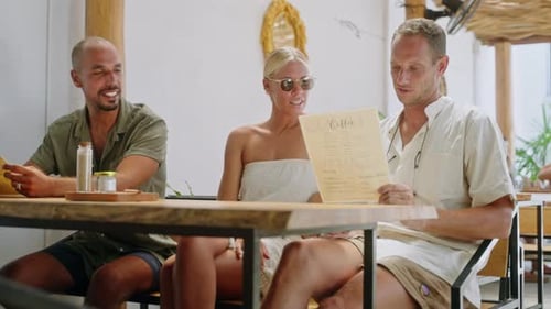 Multiracial Cheerful Friends Looking at Menu Choosing Food in Tropical Cafe Diverse Persons Sitting