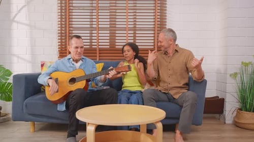 Family Playing Guitar and Singing on Couch