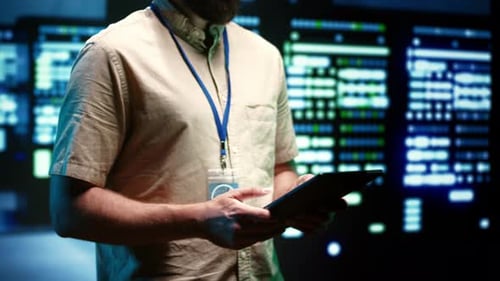 Man Works With Tablet in Data Center