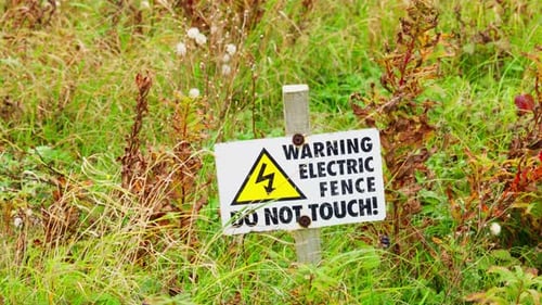 Warning sign placed in the ground to let people know the danger posed by the electric fence.