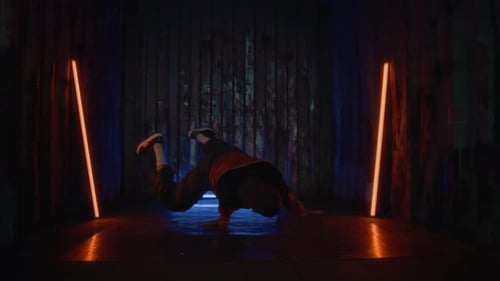 Talented Zoomer Performing Handstand Breaking Indoors in Neon Light