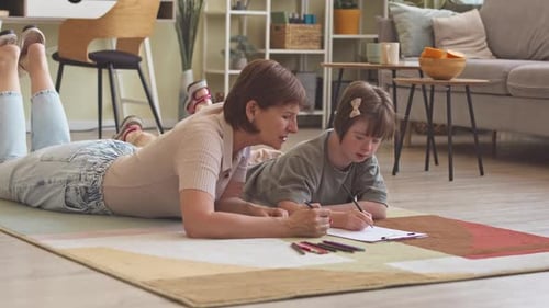 Woman and Child Drawing on Floor Together