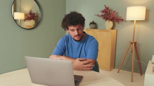 Man Reacting to Laptop in Bright Home Interior