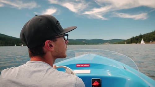 Back view of man steering in yacht on sunny day