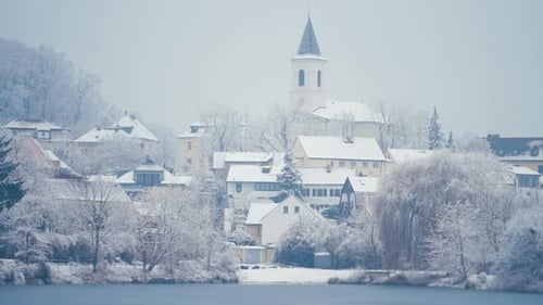 A beautiful winter view of the quiet neighborhood in Prague. Snow-covered trees and houses on the ba
