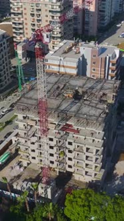 Vertical Video of Engineers Reviewing Plans While Workers Build Walls and Install Metal Beams
