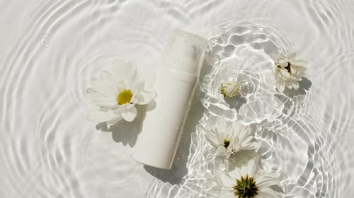 Kosmetikflasche, Fläschchen und Blumen, Kamille auf Wasseroberfläche, mit Tropfen