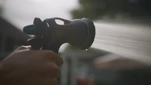 Person spraying hose. Close up.