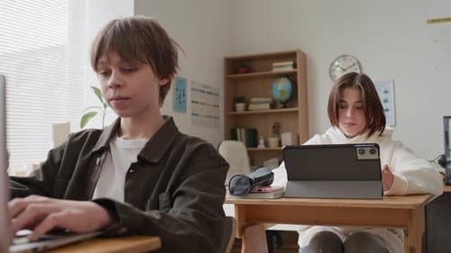 Focused Teenagers Using Laptops and Digital Tablet to Study During Class