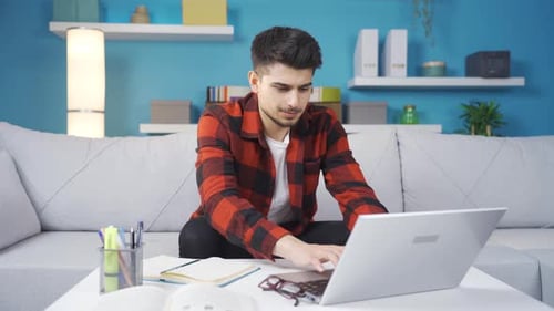 Junger Mann, der am Laptop arbeitete, war erfolgreich.
