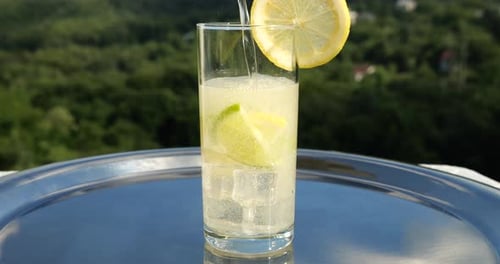 Refreshing Citrus Drink Being Poured in Sunny Setting