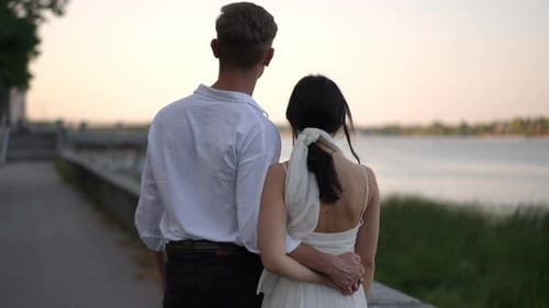 Romantic Couple Embracing at Sunset by the Water