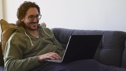 Man Waving During Video Conference at Home