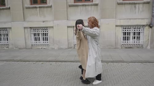 Woman Lifts Friend in an Embrace in City