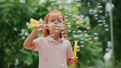 Child Blowing Bubbles in a Park on a Sunny Day