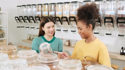 Two young women shopped in refill store, reusable bags, and zero-waste grocery.