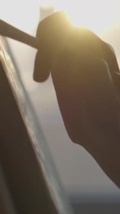 Hand Holding Paintbrush Painting During Sunset Lighting