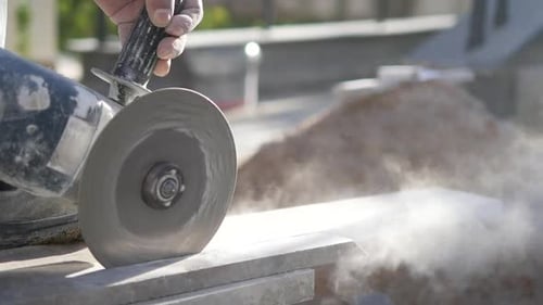 A Person is Using a Grinder to Cut an Auto Part Made of Steel