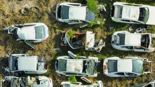 Aerial drone close-up view of a crowded car scrapyard.