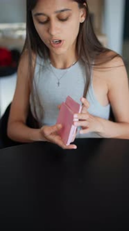 A Deck of Playing Cards is Being Meticulously Sorted By a Young Woman at a Table