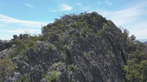Massive eroded rock outcrop stands tall above surrounding green valley