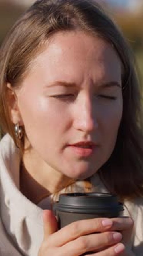 Young woman enjoying hot beverage outdoors