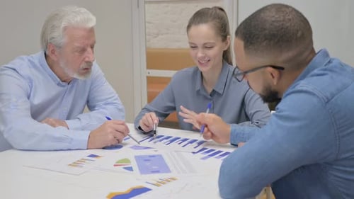 Young Woman Doing Paperwork with Colleagues