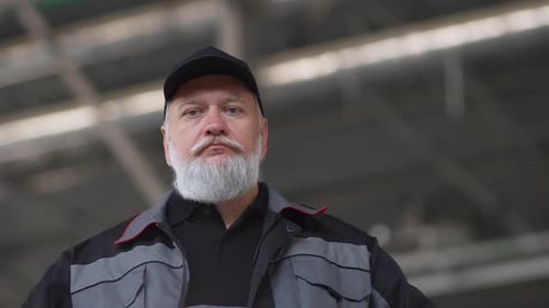 Portrait of Adult Grayhaired Worker in a Working Suit Technical Engineer Stands and Indoor the