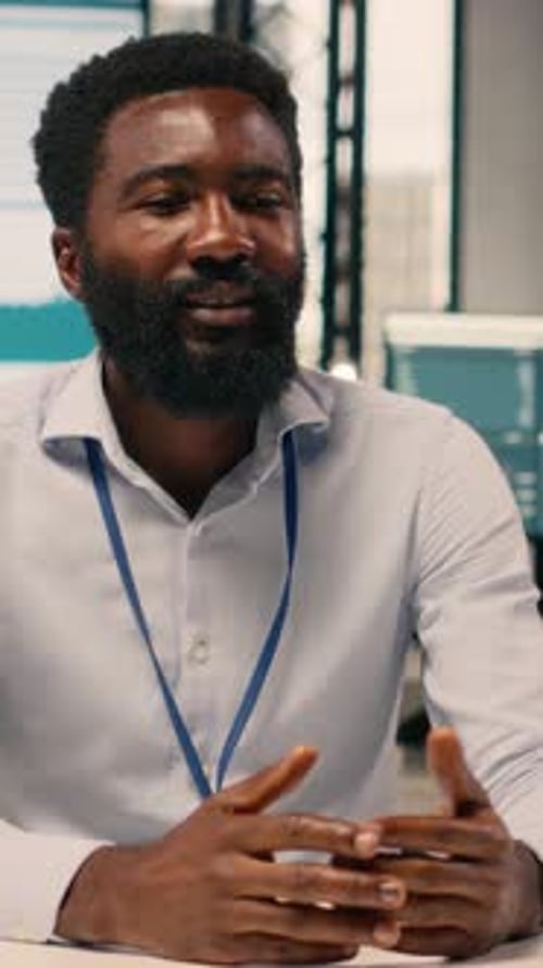 Confident Man Talks at Office Desk in Vertical Video