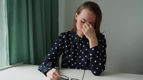 Woman Rubbing Temples Due to Headache or Eye Strain