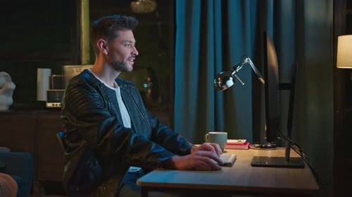 Side Shot of Emotional Success of Bearded Man Sitting at Computer and Looking at Screen Portrait of