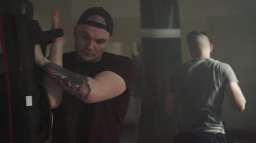 Der Trainer hält Boxausrüstung für den Boxschüler bereit
