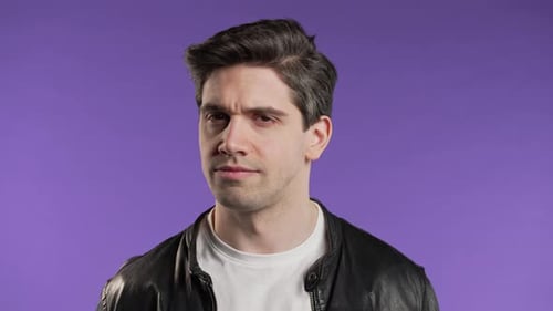 Young Man Expressing Annoyance on Purple Background