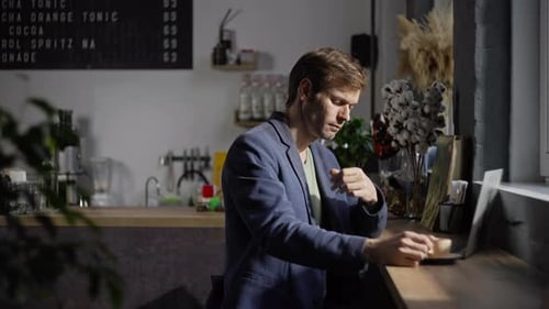 A European Guy Works at a Computer in a Coffee Shop